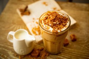A refreshing iced coffee with cream served on a sunny countertop.